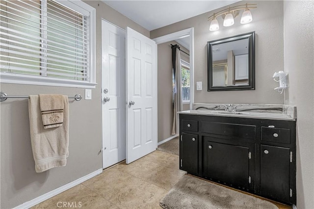 bathroom featuring tile patterned flooring, baseboards, and vanity