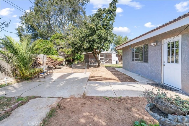 view of patio / terrace with an outbuilding and fence