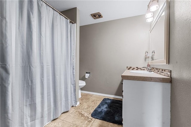 bathroom with visible vents, toilet, vanity, tile patterned flooring, and baseboards