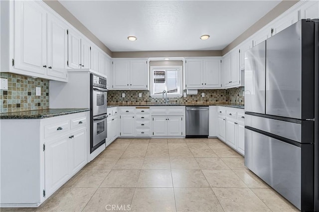 kitchen with light tile patterned floors, white cabinetry, stainless steel appliances, and a sink