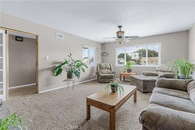 living area featuring baseboards, carpet, visible vents, and a ceiling fan