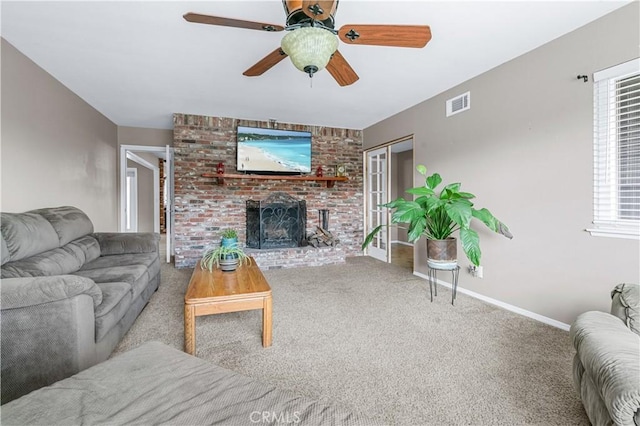 carpeted living area featuring ceiling fan, a brick fireplace, visible vents, and baseboards