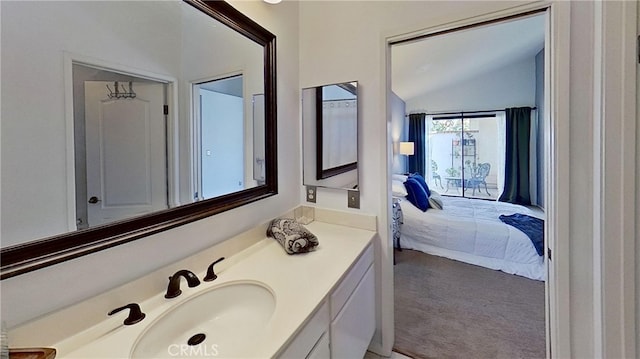 bathroom featuring lofted ceiling, connected bathroom, and vanity