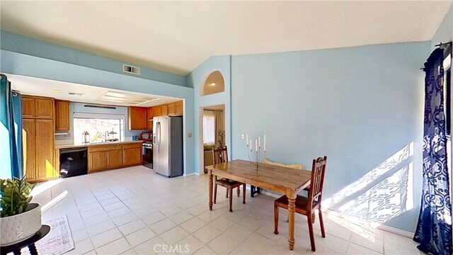 dining space with visible vents, vaulted ceiling, and light tile patterned floors