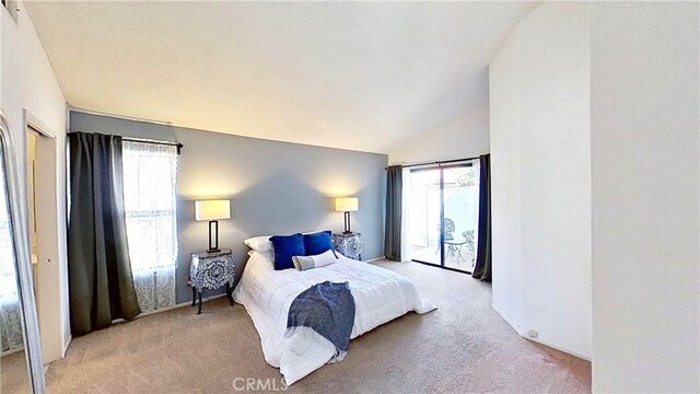 bedroom featuring access to exterior, multiple windows, vaulted ceiling, and light carpet