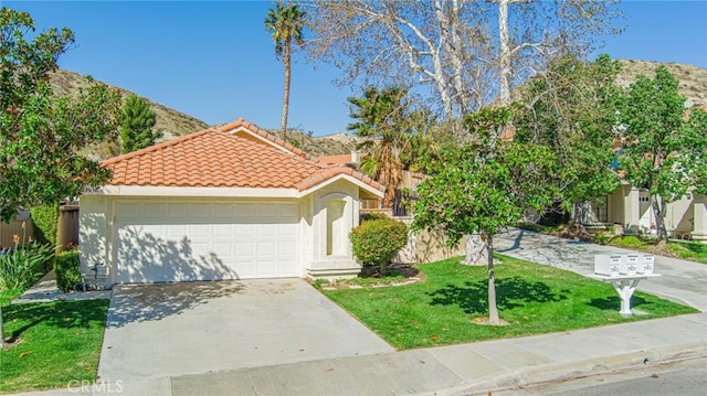 view of front of house with a garage, a tiled roof, concrete driveway, stucco siding, and a front lawn