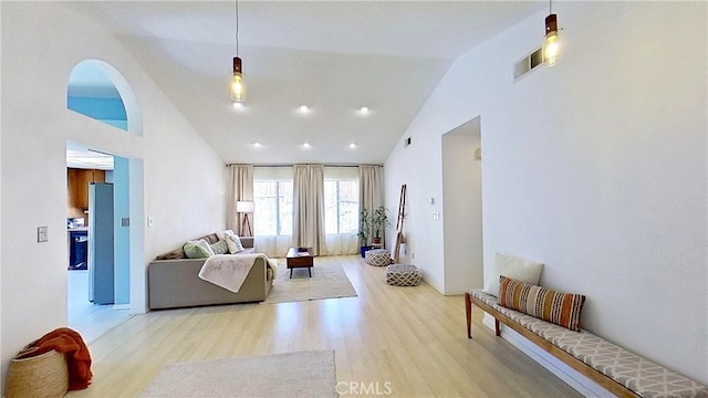 living area with high vaulted ceiling and light wood-type flooring