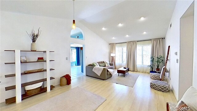 living area with high vaulted ceiling and wood finished floors