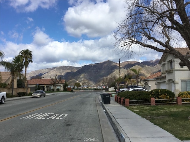 view of road featuring sidewalks, a mountain view, and curbs