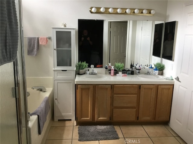 bathroom with a sink, a bath, and tile patterned floors