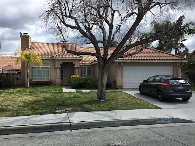 mediterranean / spanish-style home featuring a chimney, stucco siding, an attached garage, driveway, and a front lawn