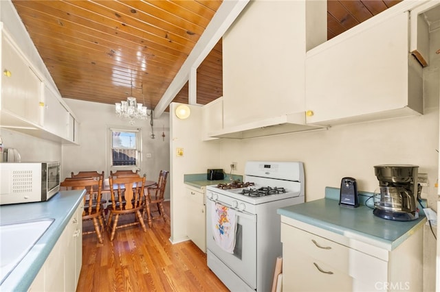 kitchen featuring light wood finished floors, white range with gas cooktop, white cabinets, wooden ceiling, and under cabinet range hood