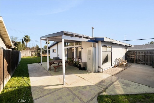 back of property with a yard, a fenced backyard, stucco siding, and a patio