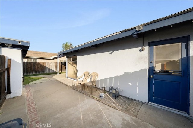 view of home's exterior featuring fence, a patio, and stucco siding