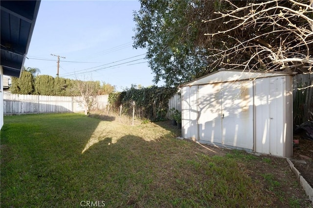 view of yard featuring an outbuilding, a shed, and a fenced backyard