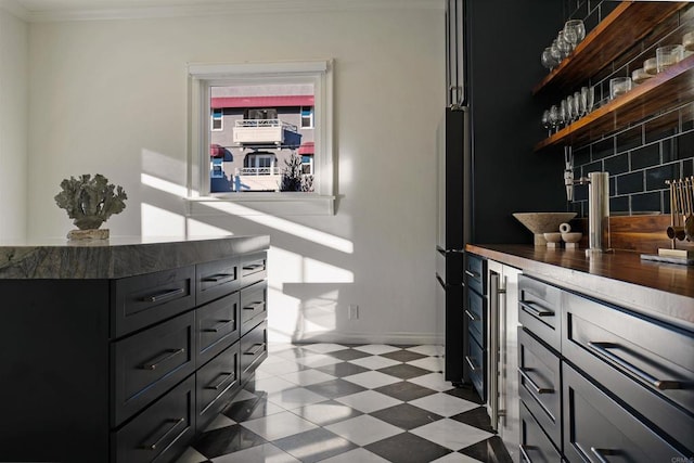 interior space featuring light floors, crown molding, baseboards, and backsplash