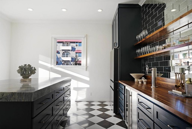 bar featuring dark floors, ornamental molding, recessed lighting, and bar