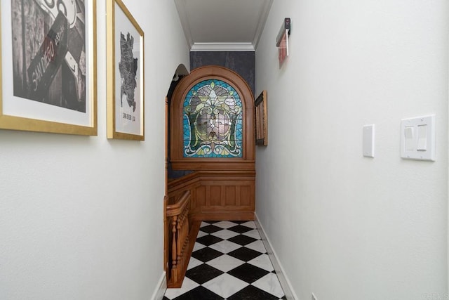 hall featuring baseboards, ornamental molding, and tile patterned floors