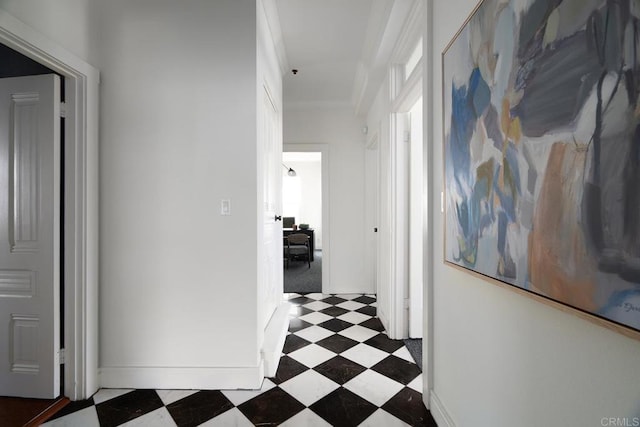 hallway featuring baseboards and tile patterned floors