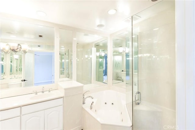 bathroom featuring a shower stall, a tub with jets, and vanity