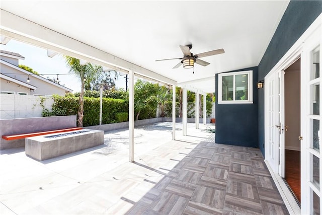 unfurnished sunroom featuring ceiling fan