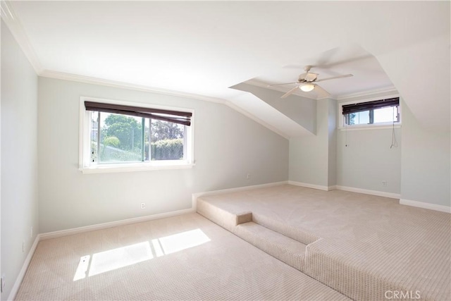 additional living space with baseboards, a ceiling fan, and light colored carpet