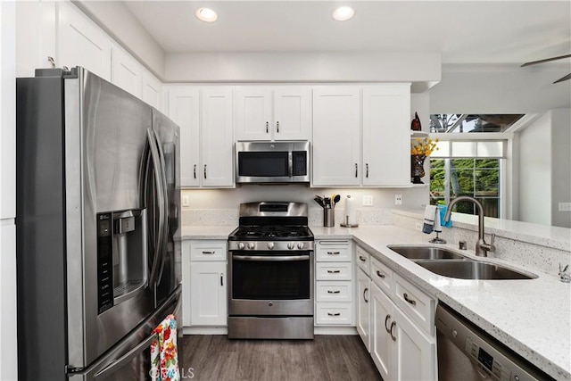 kitchen featuring white cabinets, dark wood-style floors, stainless steel appliances, and a sink