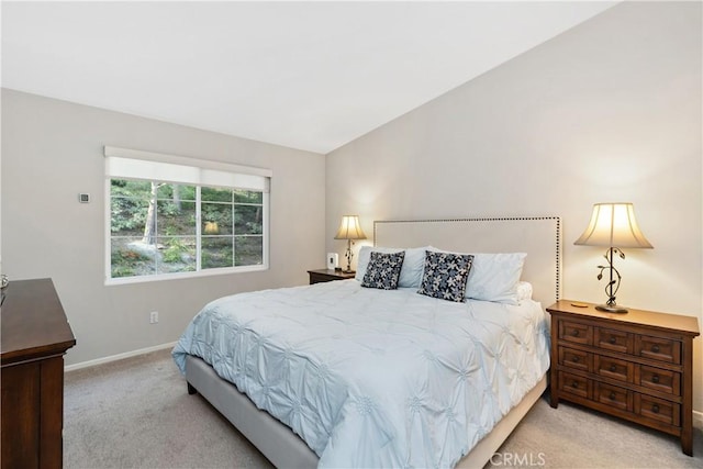 carpeted bedroom featuring lofted ceiling and baseboards