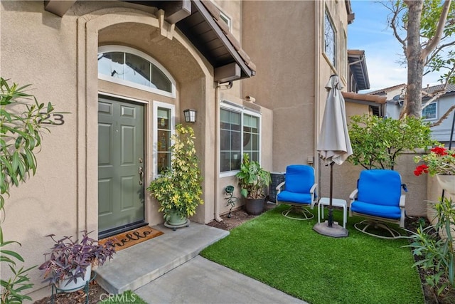 view of exterior entry with stucco siding