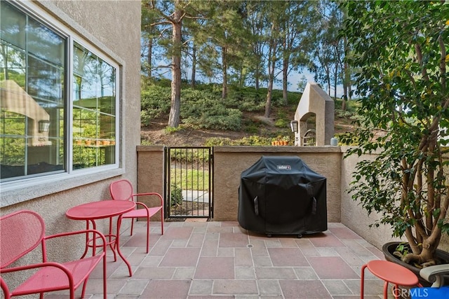 view of patio with a gate, a grill, and fence