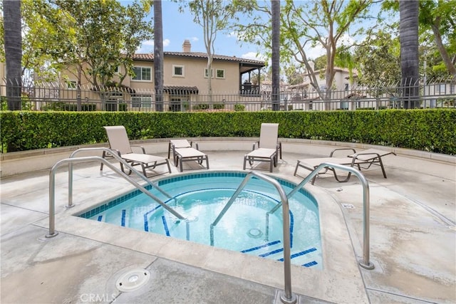 view of pool featuring a patio area, a hot tub, and fence