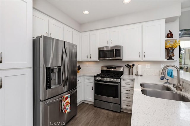 kitchen featuring appliances with stainless steel finishes, white cabinetry, and a sink