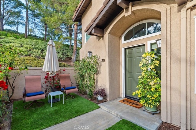 doorway to property featuring stucco siding