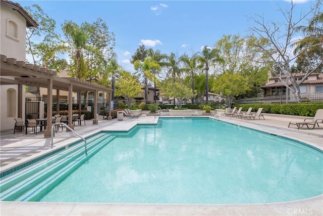 community pool with fence, a pergola, and a patio