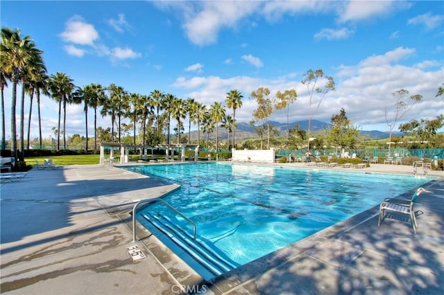 pool with a patio area and a mountain view