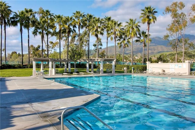 pool with a patio area, a mountain view, fence, and a pergola