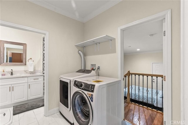 washroom with ornamental molding, laundry area, washer and dryer, marble finish floor, and a sink