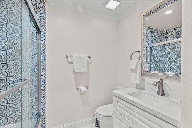 bathroom featuring vanity, crown molding, toilet, and baseboards