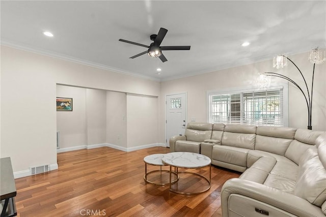 living area featuring visible vents, crown molding, ceiling fan, baseboards, and wood finished floors