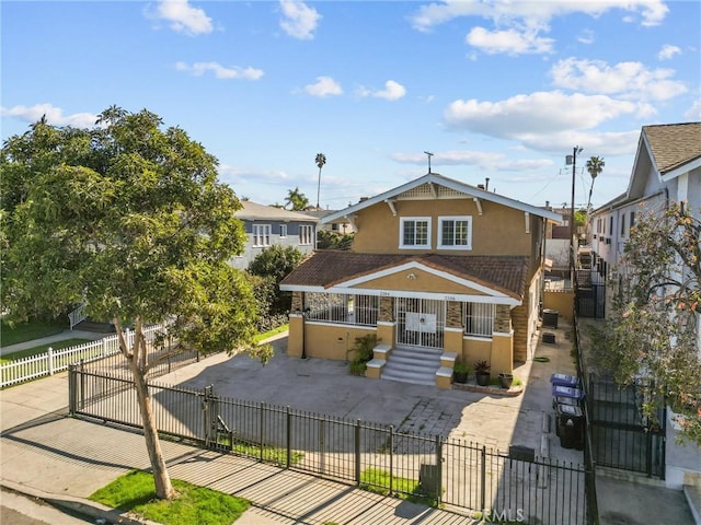 view of front of home featuring a fenced front yard, stucco siding, and a gate