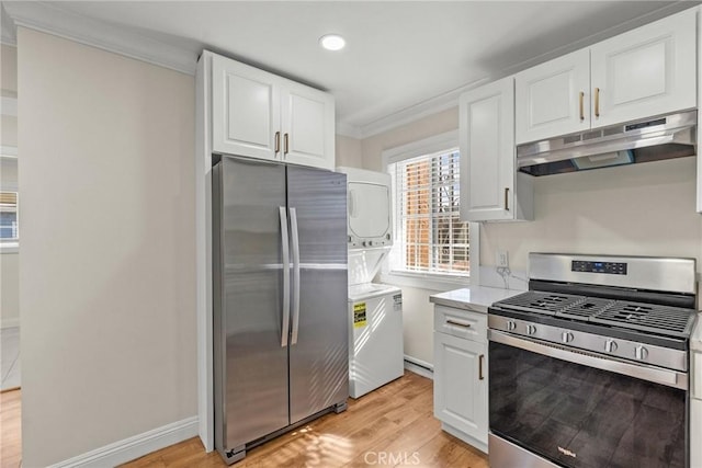 kitchen featuring ornamental molding, stainless steel appliances, white cabinets, stacked washer / drying machine, and under cabinet range hood