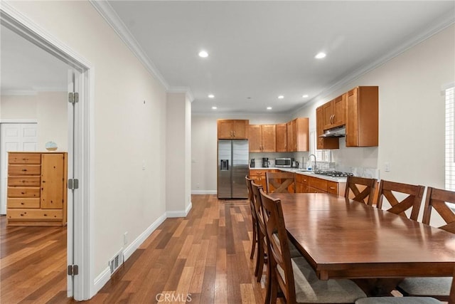 dining room with recessed lighting, visible vents, ornamental molding, and light wood finished floors