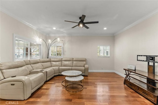 living room with wood finished floors, a wealth of natural light, and ornamental molding