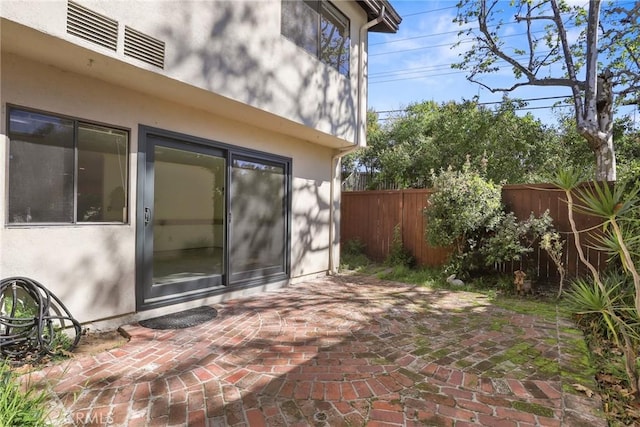 exterior space with visible vents, fence, and a patio