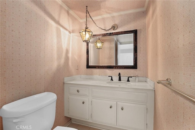 bathroom with ornamental molding, vanity, toilet, and wallpapered walls