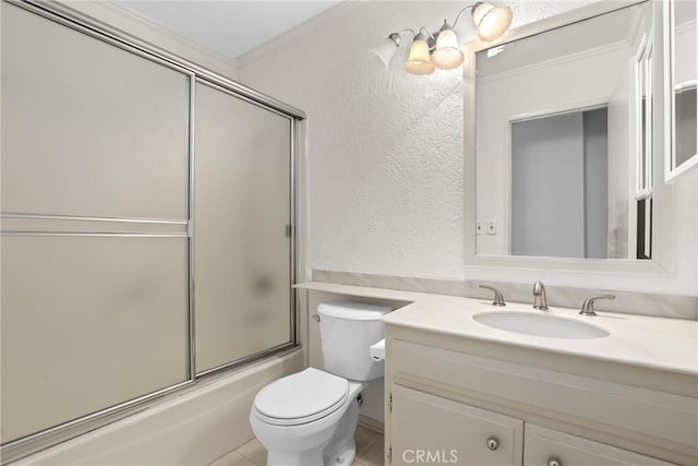 full bathroom featuring a textured wall, toilet, ornamental molding, combined bath / shower with glass door, and vanity