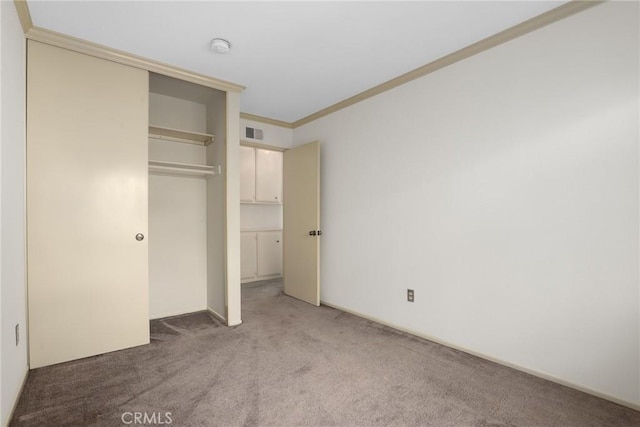 unfurnished bedroom with light carpet, ornamental molding, a closet, and visible vents