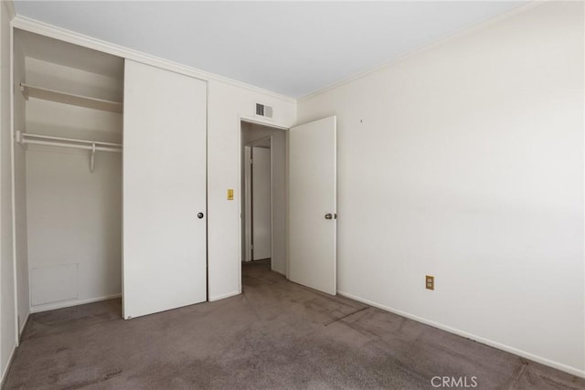 unfurnished bedroom with carpet floors, a closet, visible vents, and crown molding