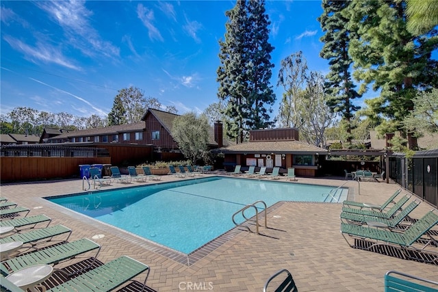 community pool featuring fence and a patio