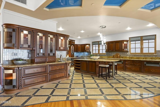 kitchen with decorative light fixtures, a breakfast bar, visible vents, and decorative backsplash